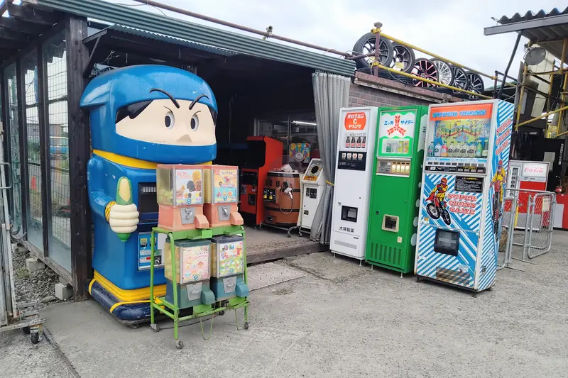 淵野辺駅南口「中古タイヤ市場相模原店」内にある24時間営業の「レトロ自販機コーナー」_入口左手にあるジュースの自動販売機とガチャ